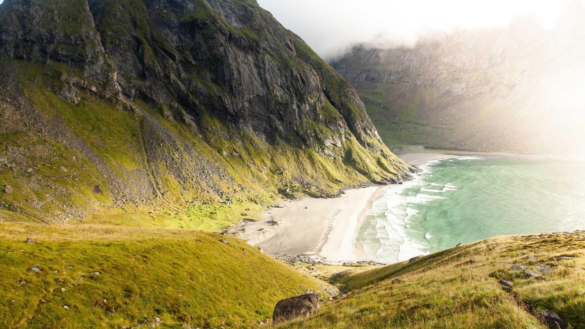 Scenic view of majestic mountains meeting a serene beach, showcasing the beauty of Indian holiday destinations.